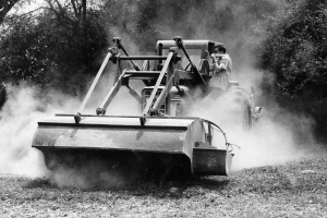 Fred Swartzendruber tests the MCC bombie beating tractor in Xieng Khouang Province, Laos. (MCC Photo/Jan Swartzendruber) 1980-1985